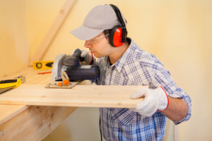 Carpenter using a circular saw to cut a wood board